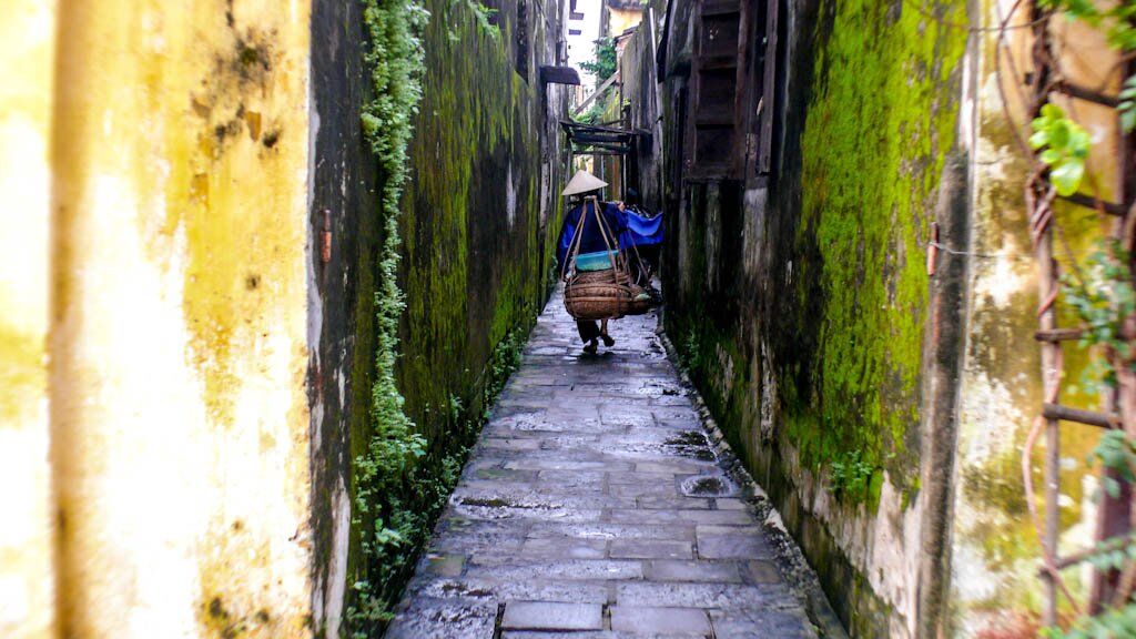 Hoi An, Vietnam - Местна жена върви по малките улички на Хой Ан, Виетнам.